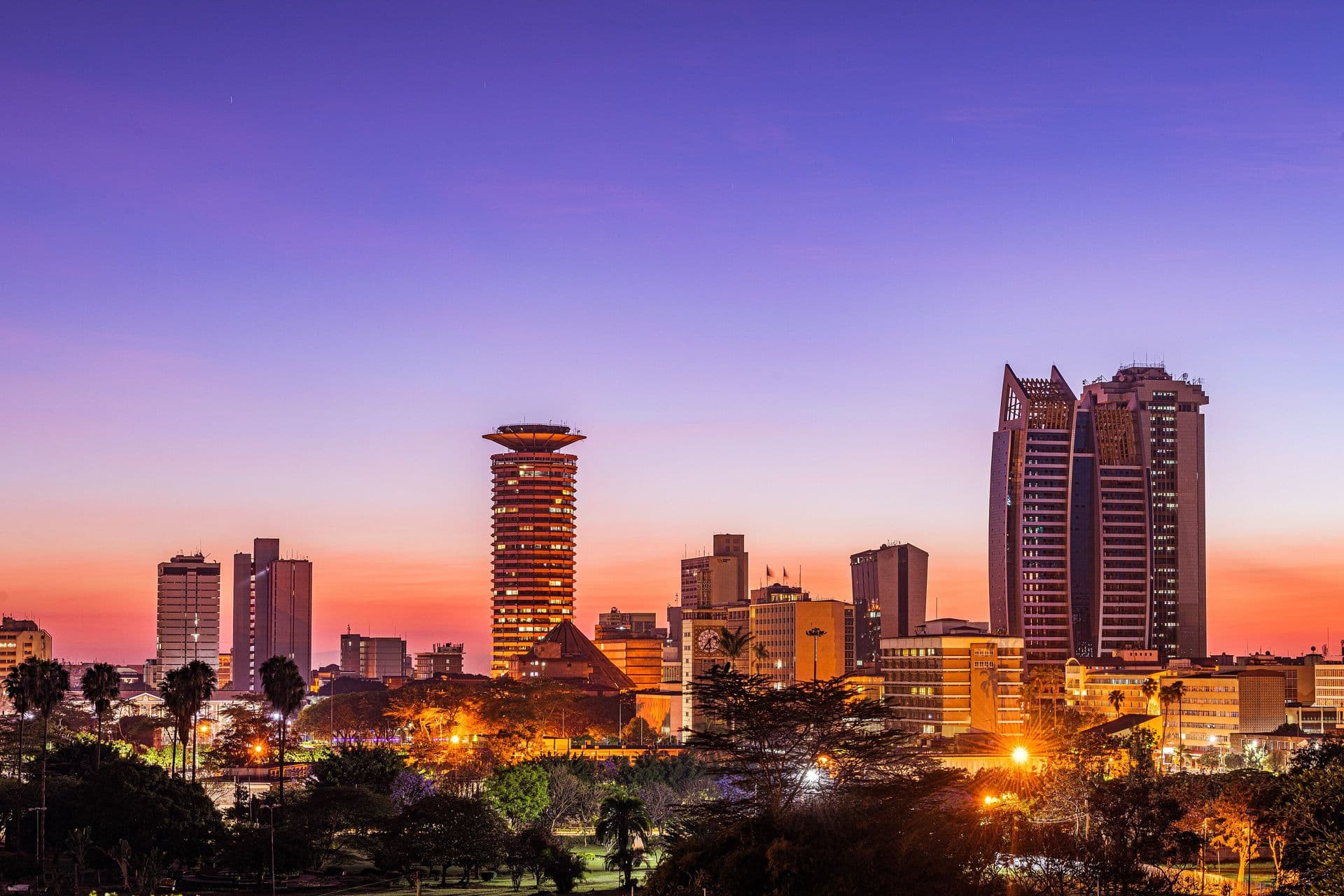 The Nairobi skyline lit up at dusk under a purple sky