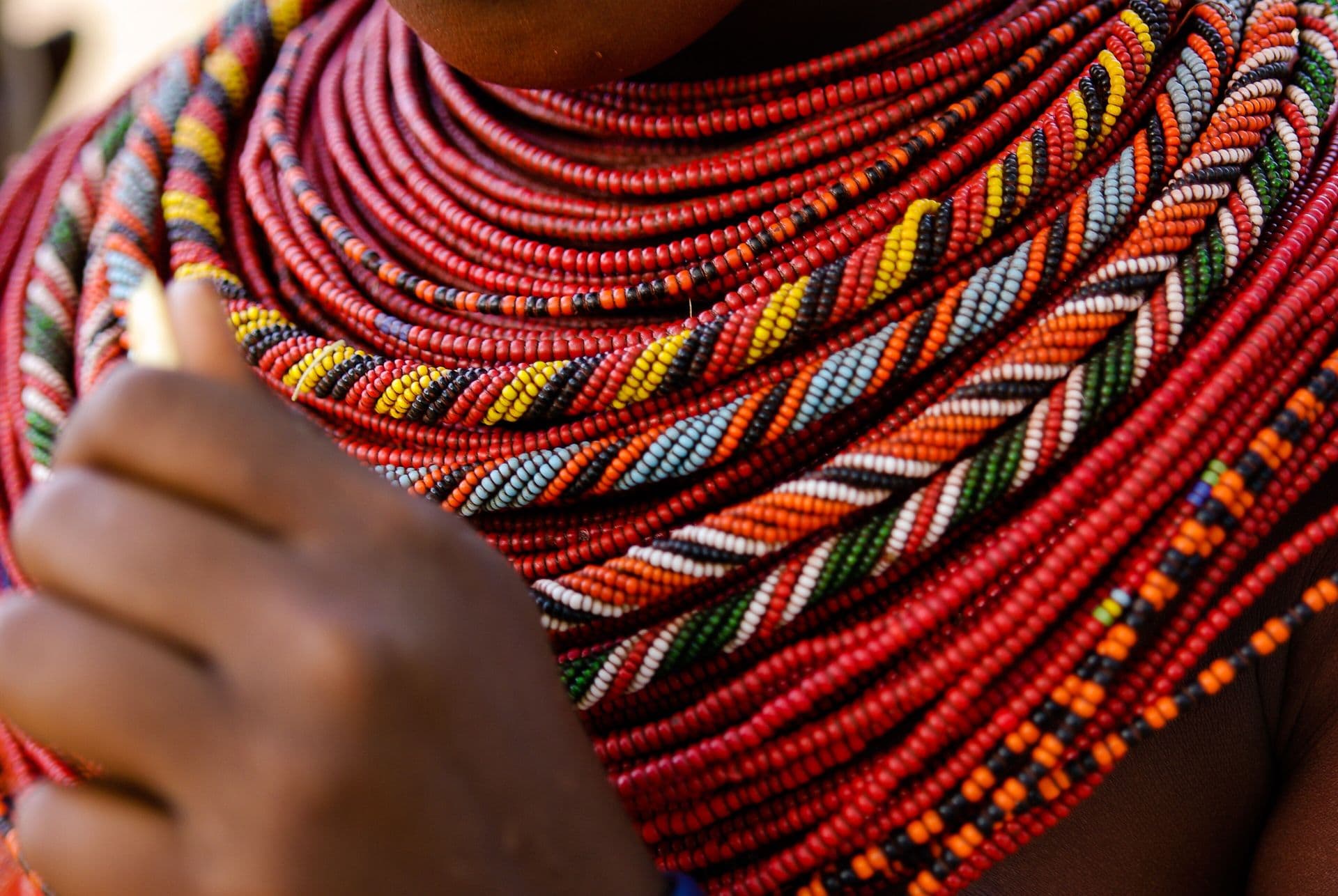 Close-up of many strands of red, white and yellow beaded necklaces worn by a Samburu girl